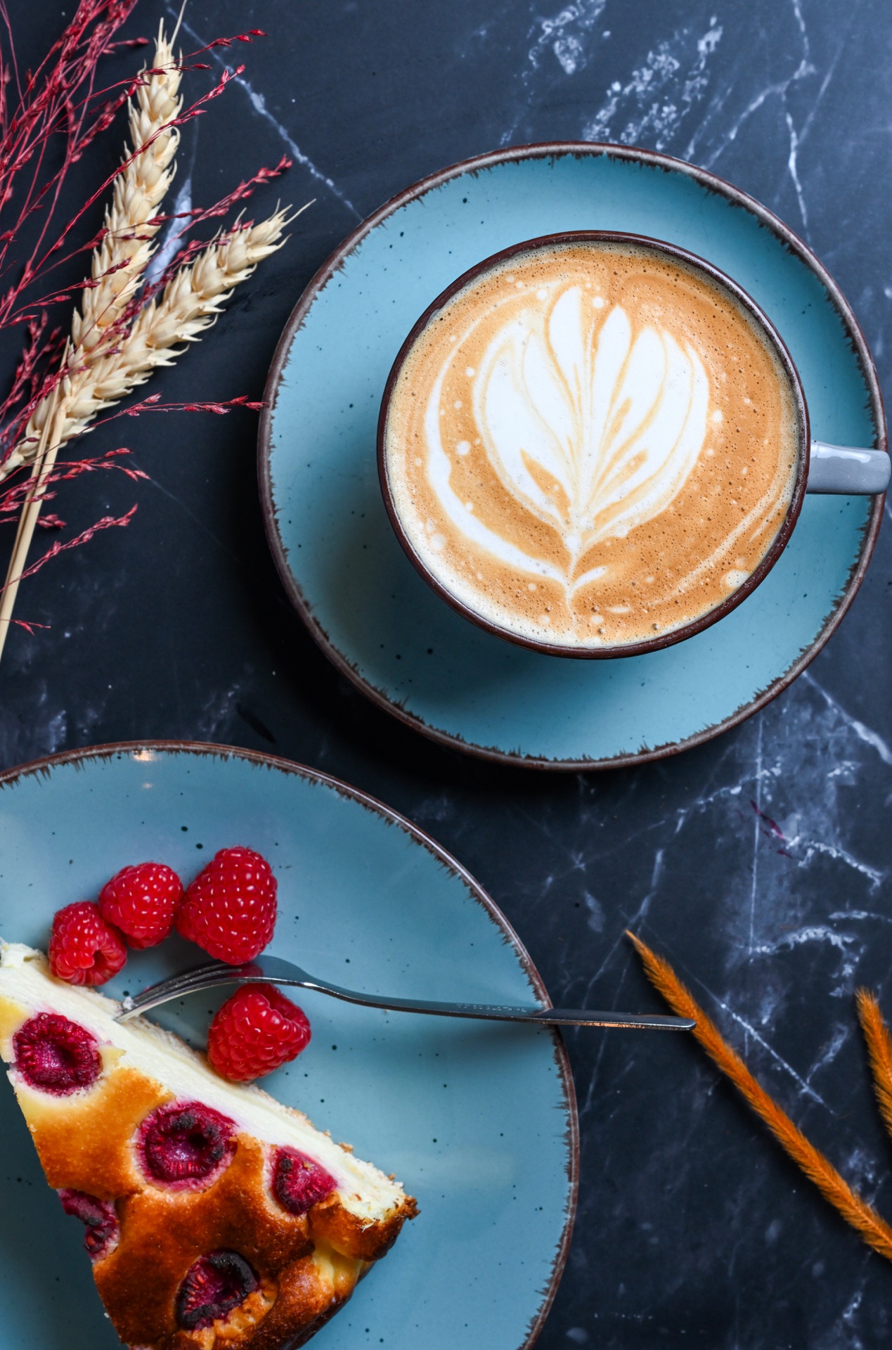 Cappuccino mit Kuchen und Himbeeren